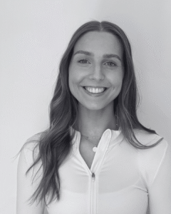 Grace, Business Development Manager at Feast and Flow, smiling in a white zip-up top against a plain background.